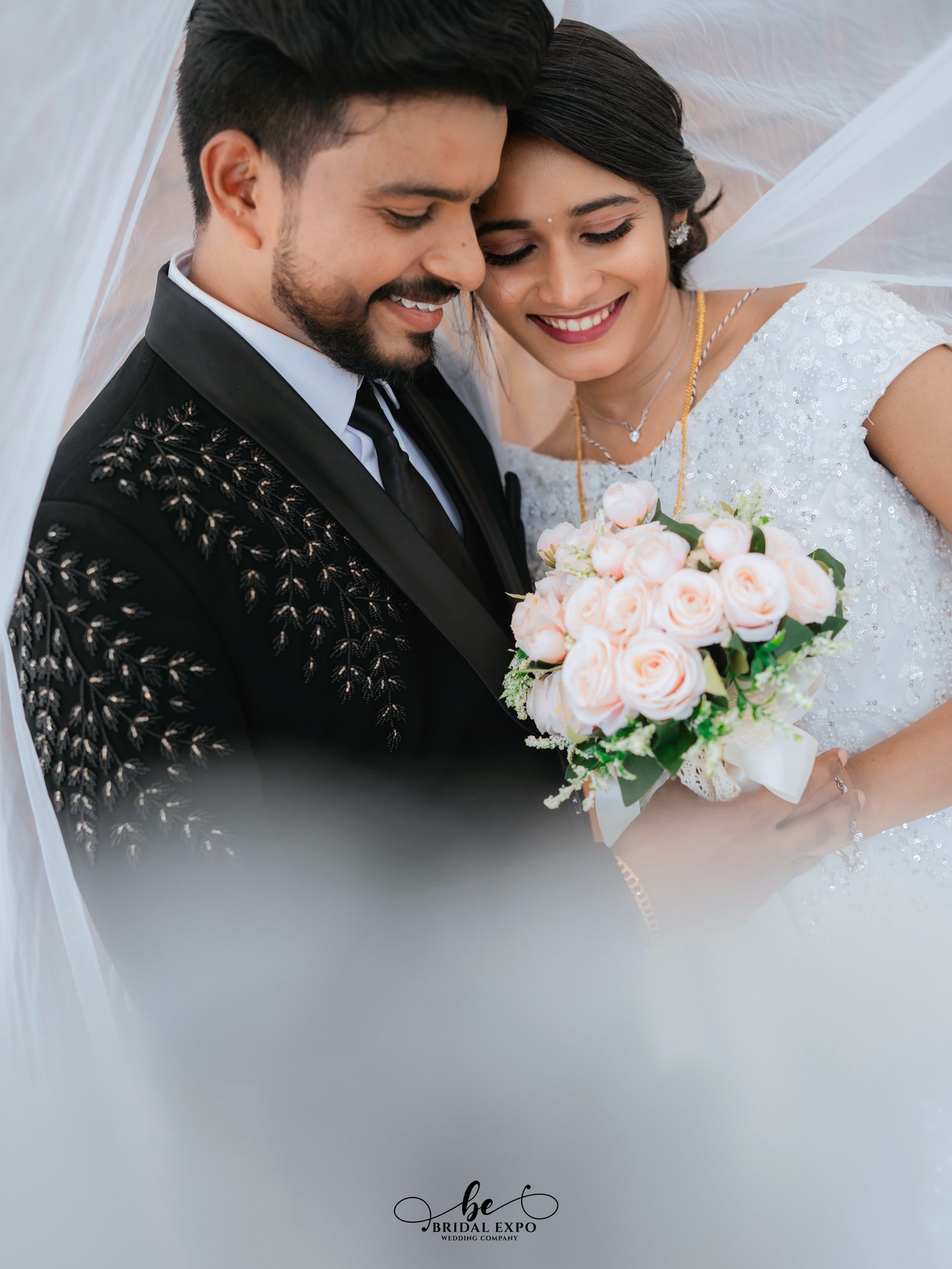 A couple smiling at each other in traditional celebration attire